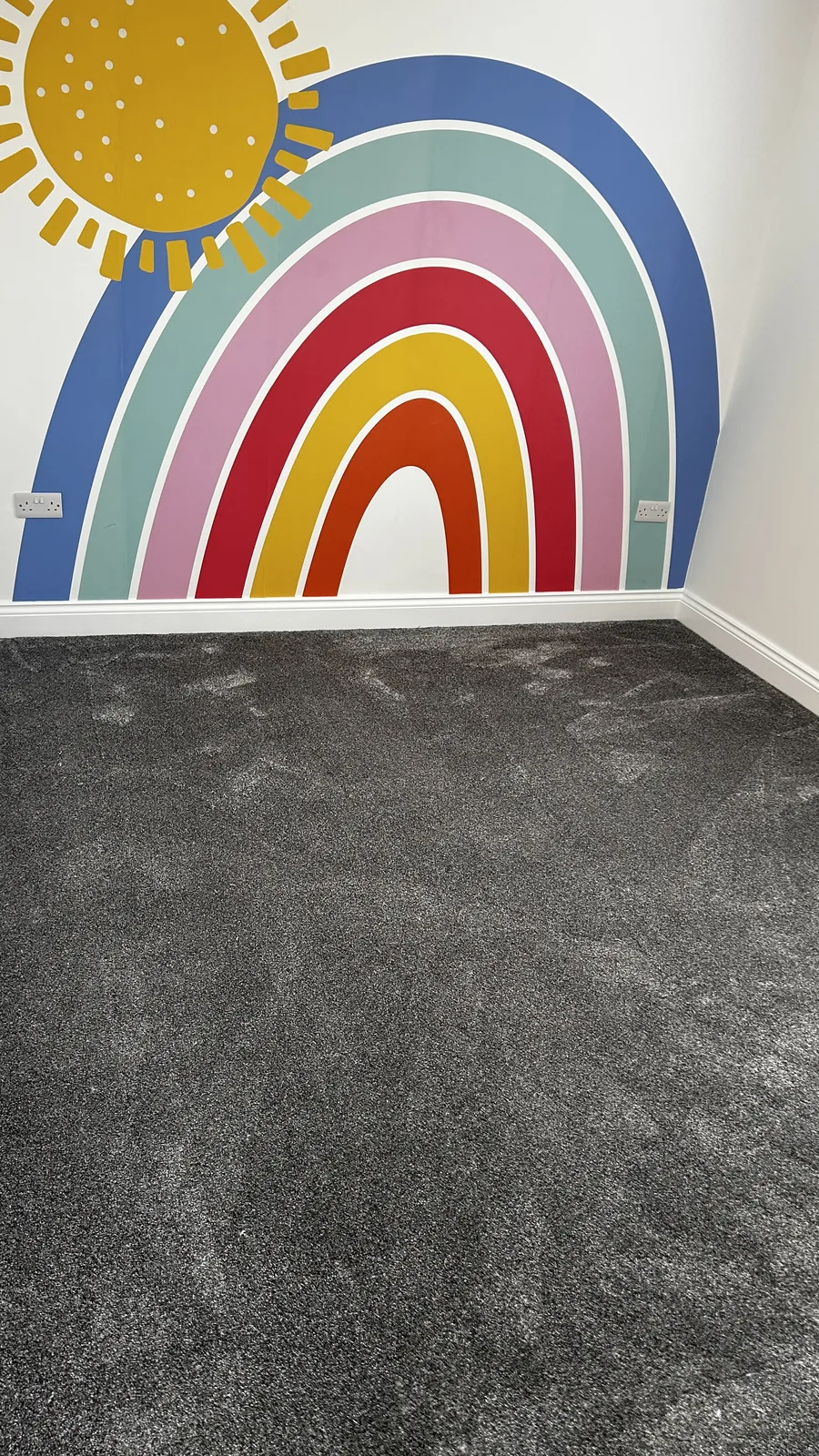 Dark carpet fitted beside a colourful feature wall