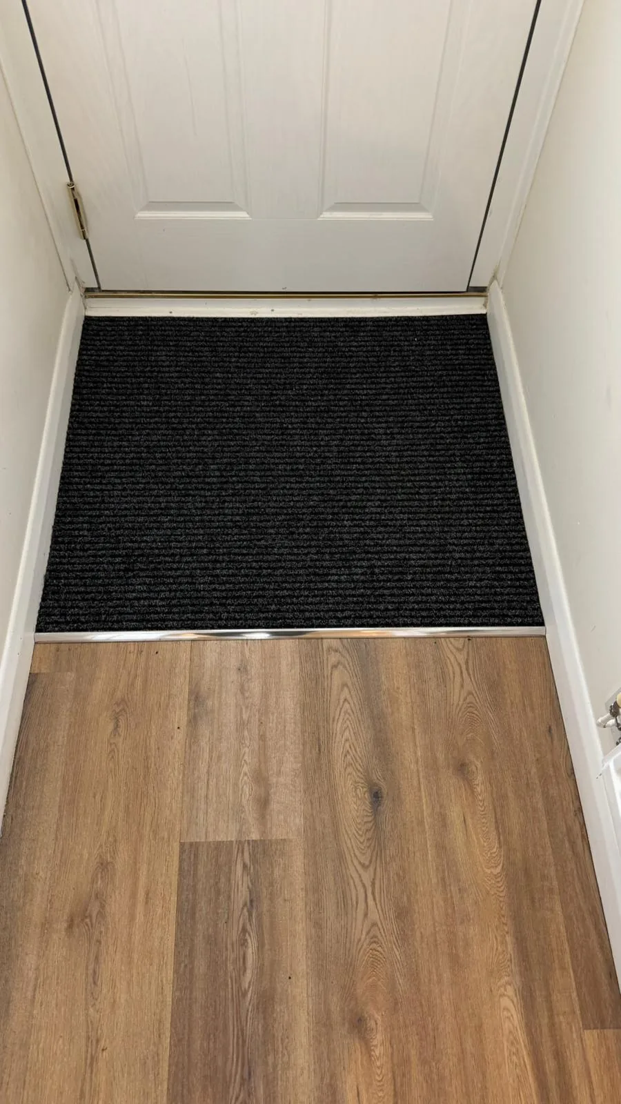 Dark inset carpet fitted within a hard floor