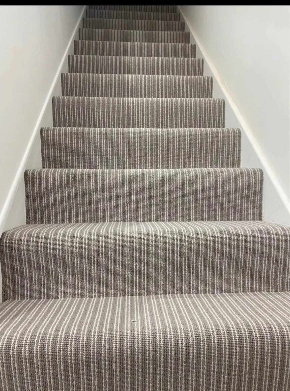 Striped carpet fitted on a straight staircase