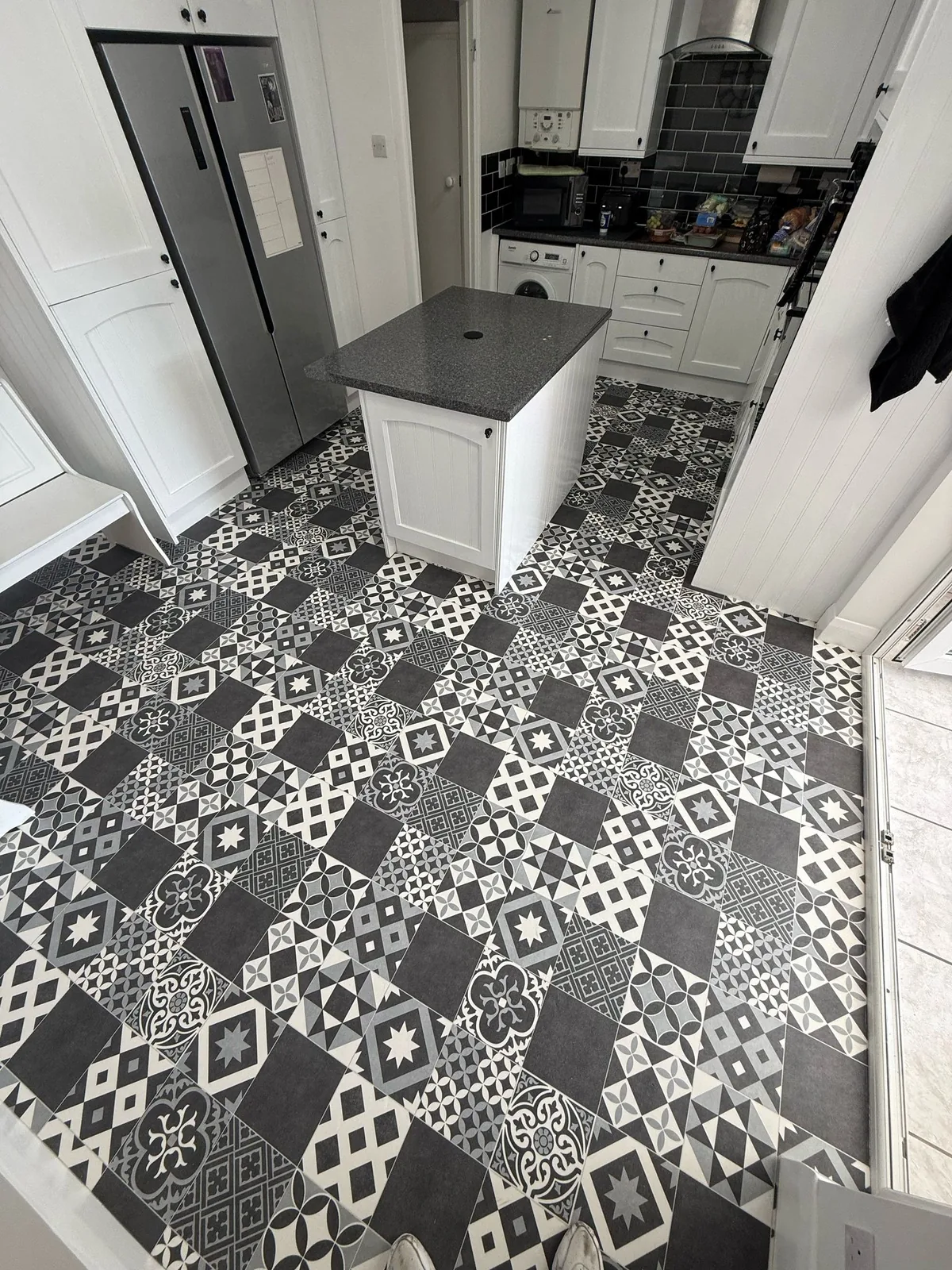 Black and white patterned vinyl flooring in a kitchen