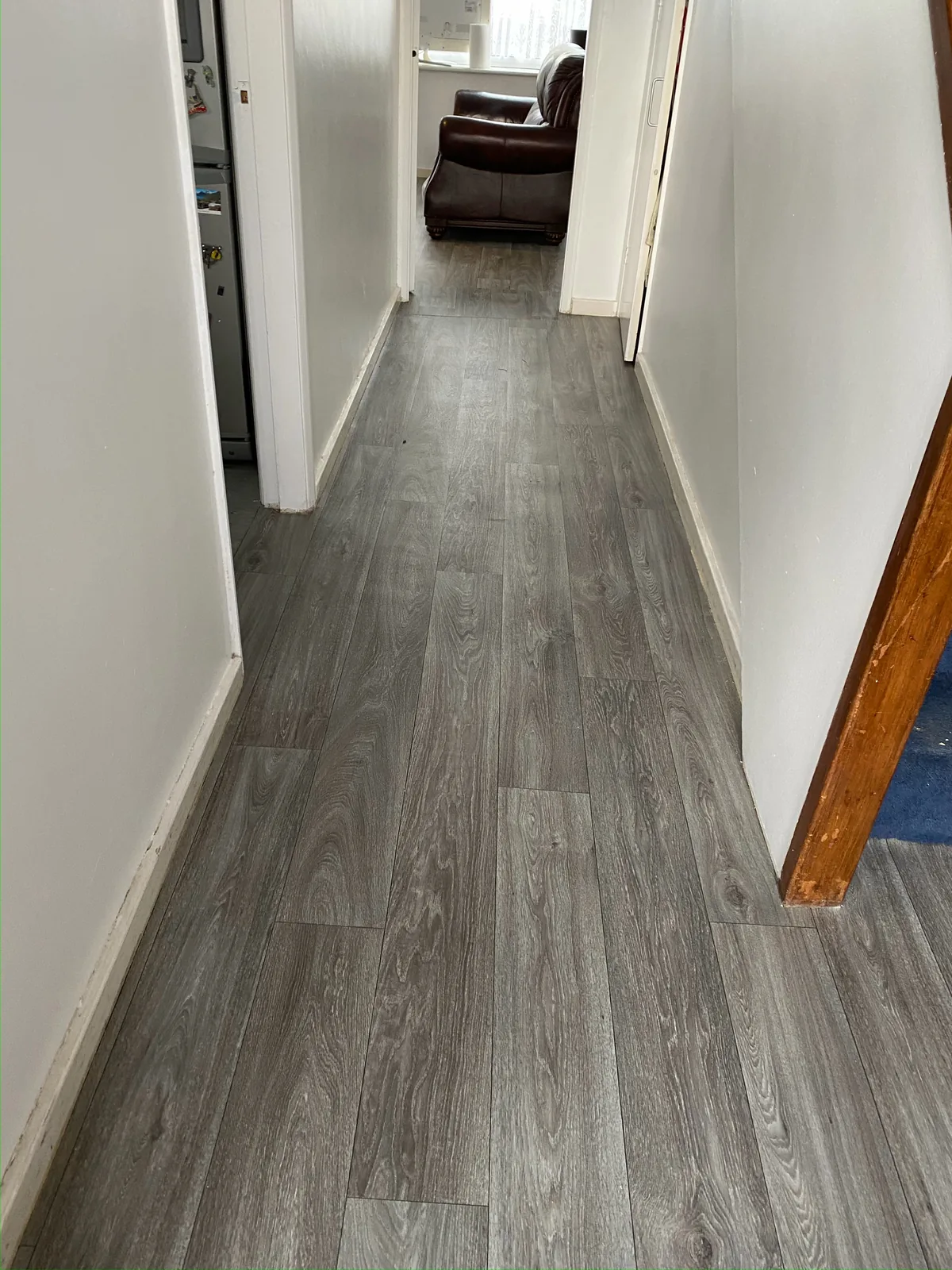 Grey wood-effect vinyl flooring along a hallway