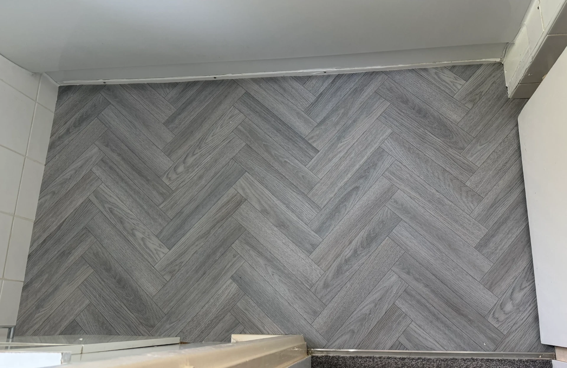 Grey herringbone lino flooring fitted across a small room