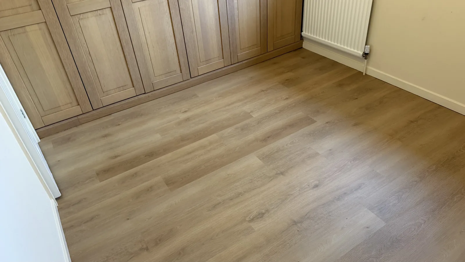 Wood-effect LVT fitted beside built-in cupboards